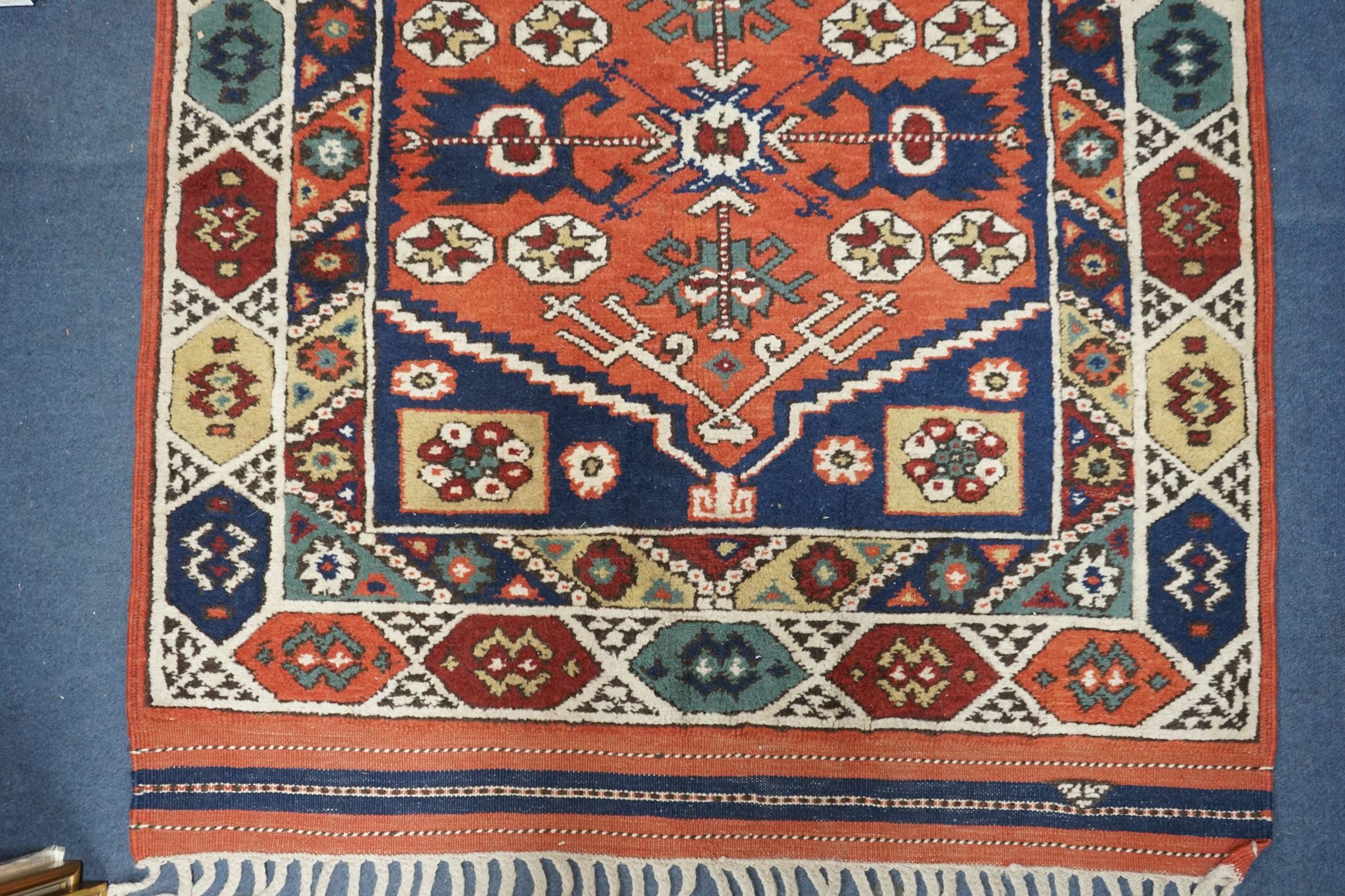 A Caucasian red ground mat, 120 x 95cm